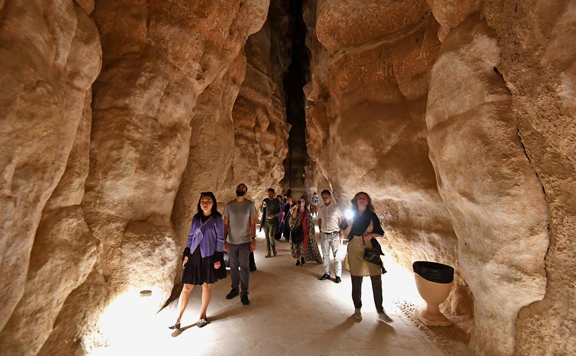 Туристы в пещере в горе Аль-Агра недалеко от города Эль-Хаса в Саудовской Аравии