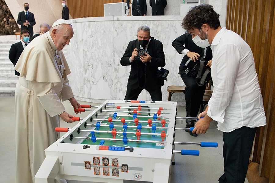Папа Римский Франциск играет в настольный футбол с одним из верующих