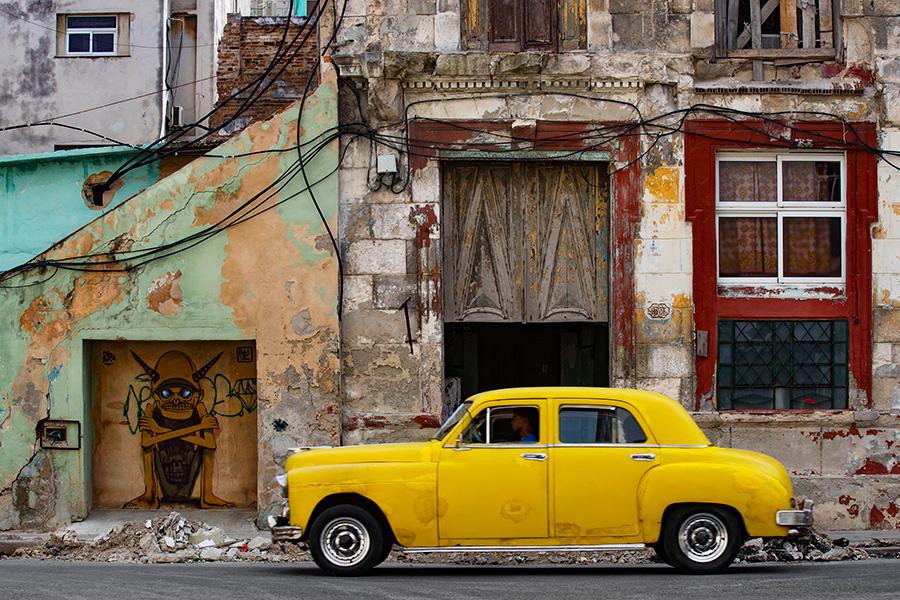Старый автомобиль перед обветшалым зданием в Гаване, 4 января 2024 года