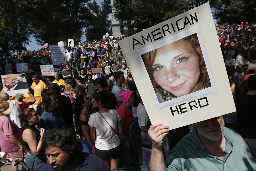 Контрпротестующий держит фото Хизер Хейер, погибшей во время наезда автомобиля на участников митинга против ультраправых в Шарлоттсвилле 12 августа 2017 года


