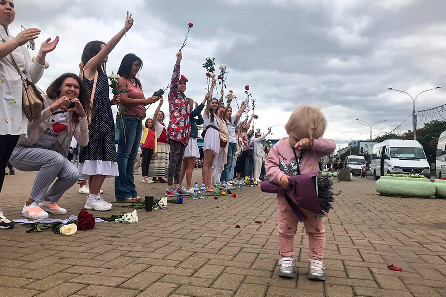 Собравшиеся у Комаровского рынка женщины стояли цепью, держа в руках цветы