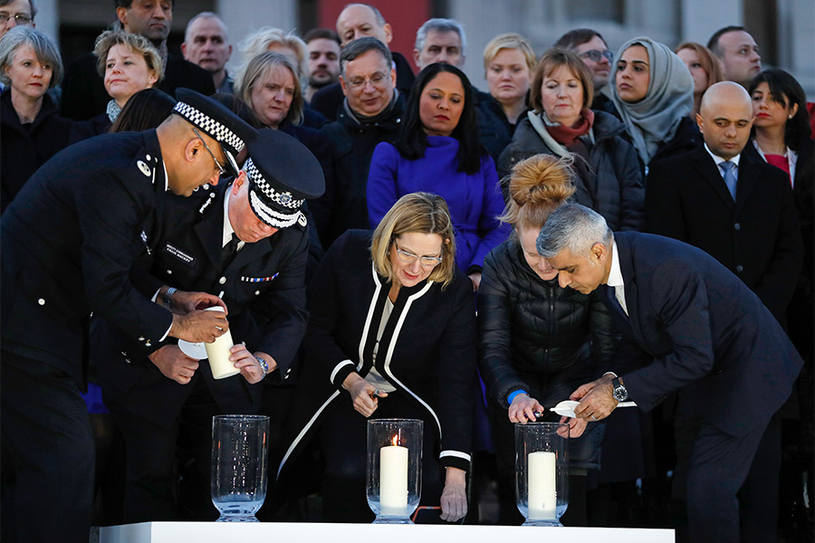 Мэр Лондона Садик Хан (справа), министр внутренних дел Великобритании Эмбер Радд и&nbsp;комиссар лондонской полиции Крейг Маккей&nbsp;(второй слева) зажигают свечи.
