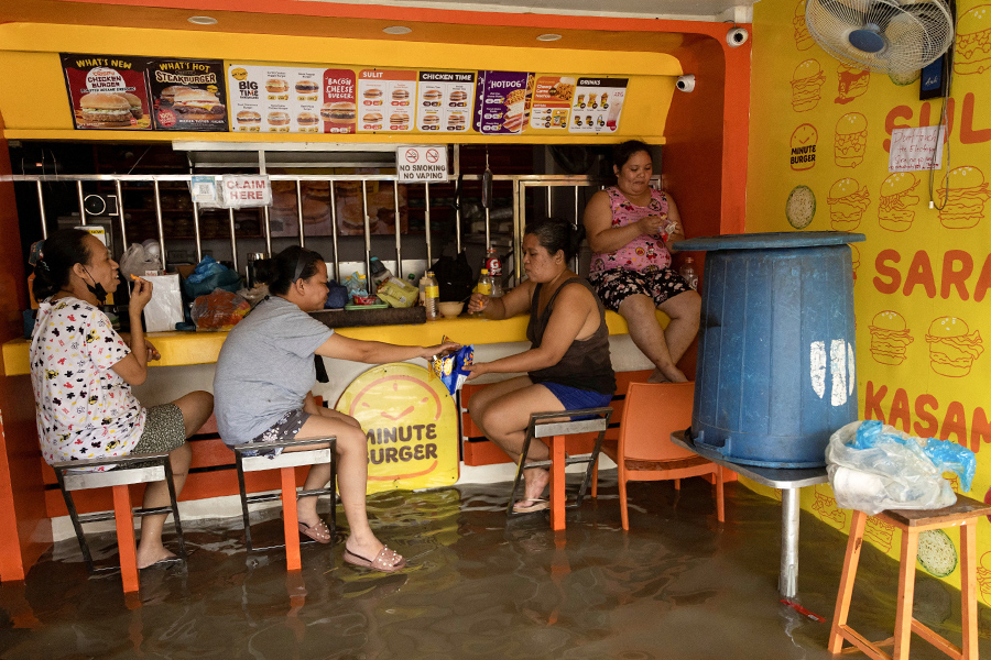 Имус, провинция Кавите. Сотрудницы общепита ждут, когда спадет наводнение