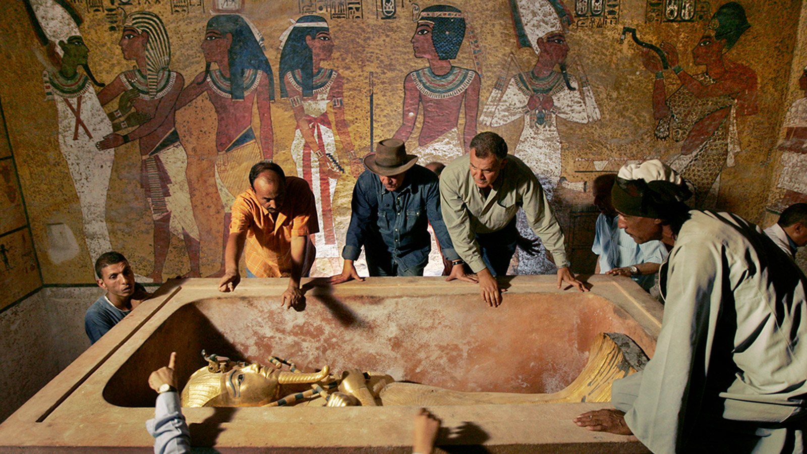 <p>Захи Хавасс (на заднем плане, третий слева), глава Верховного совета древностей Египта, наблюдает за извлечением мумии царя Тутанхамона из его каменного саркофага в подземной гробнице в Долине Царей в Луксоре 4 ноября 2007 года. Это был первый раз, когда широкая общественность смогла увидеть &laquo;лицо&raquo; древнеегипетского правителя</p>