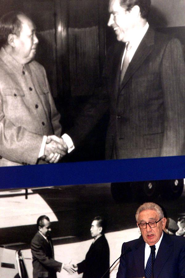 Бывший госсекретарь США Генри Киссинджер произносит речь перед фотографиями встречи&nbsp;президента США Ричарда Никсона (справа) с китайским лидером&nbsp;Мао Цзэдуном&nbsp;(вверху) и встречи Никсона с&nbsp;премьер-министром Чжоу Эньлаем (внизу) 28 февраля 1972 года