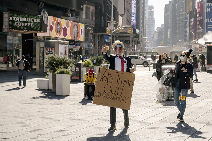 Протестующий в костюме президента США Дональда Трампа держит плакат с надписью &laquo;Голосуй против&nbsp;него!&raquo; в районе Таймс-сквер в Нью-Йорке, 4 ноября