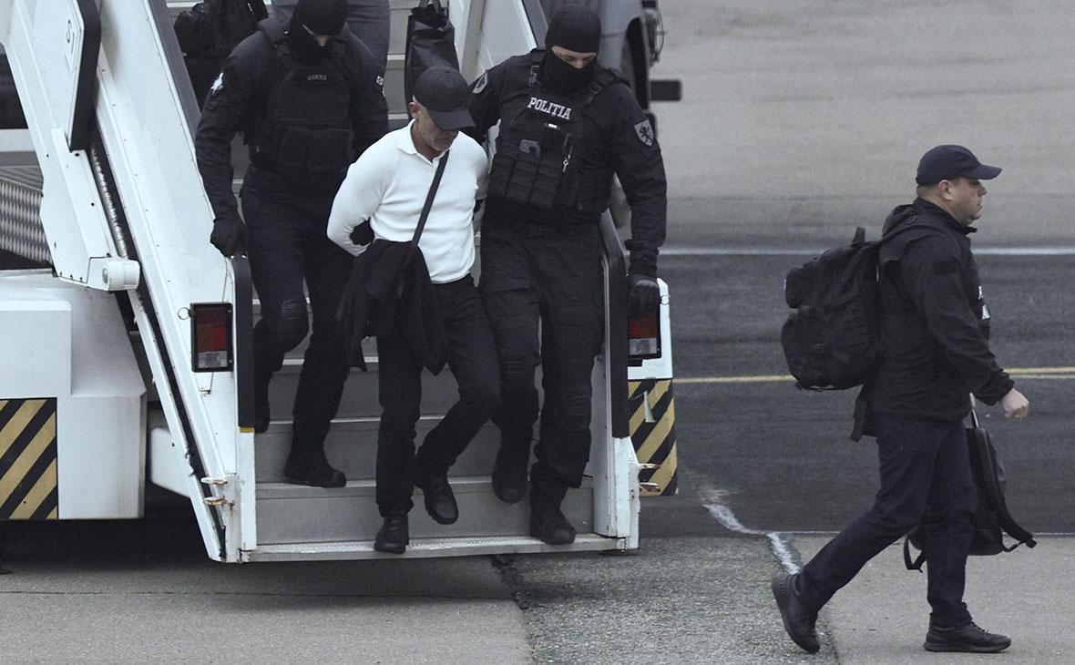 Владимир Плахотнюк, экстрадированный из Греции, выходит из самолета вместе с сотрудниками правоохранительных органов в аэропорту Кишинева, Молдова, 25 сентября 2025 года