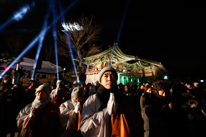 Буддистские монахи и верующие встречают Новый год в храме Бонгеон в Сеуле.