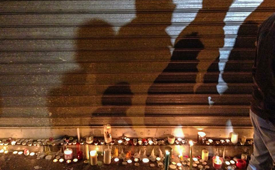 Принесенные парижанами свечи на месте убийства у ресторана Сarillon