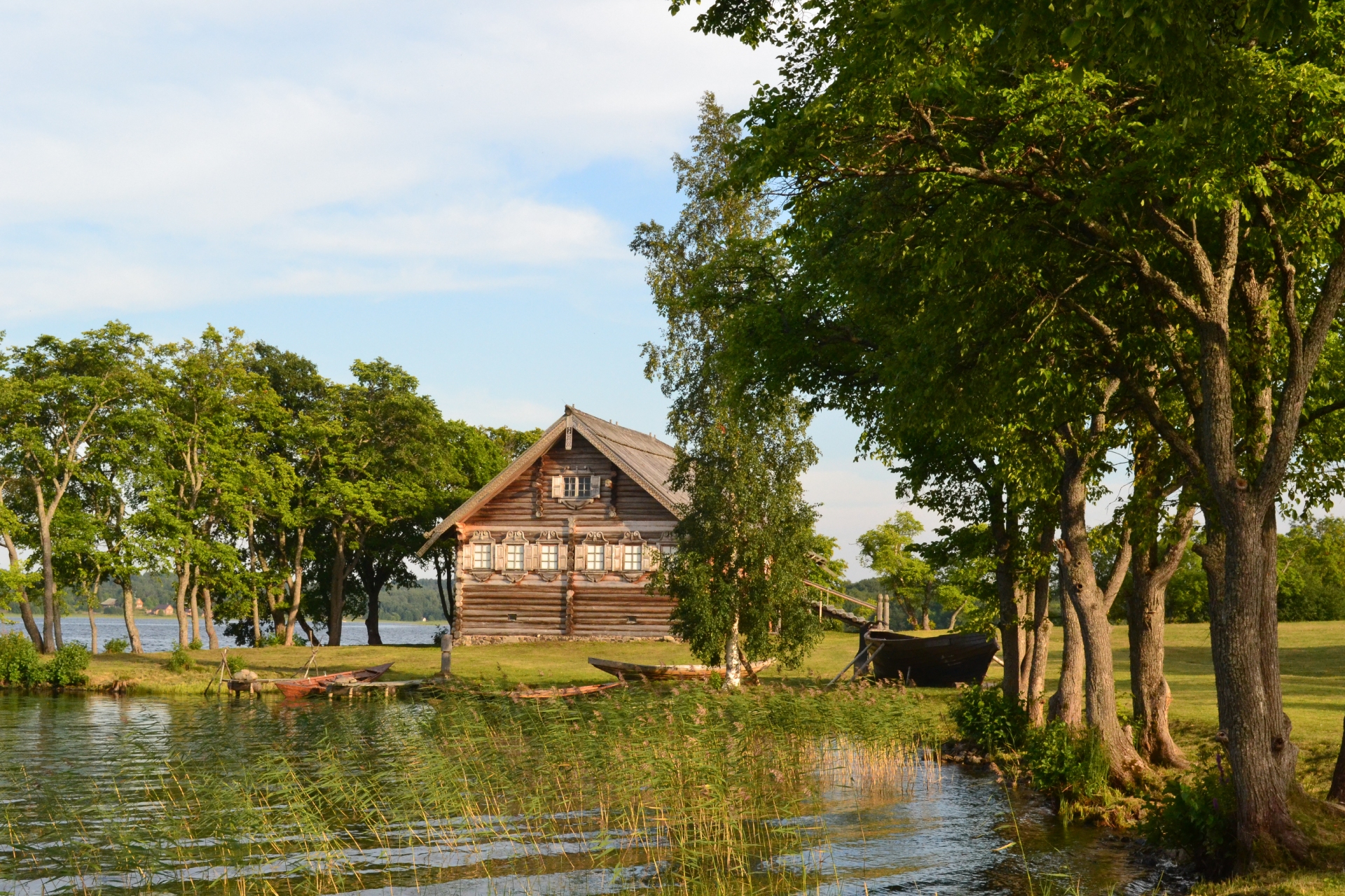 Деревенский деревянный дом с лодкой на берегу Онежского озера, Карелия
