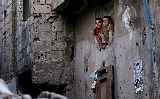 Дети выглядывают из окна одного из домов в районе Дахания, Дамаск, Сирия (архивное фото)