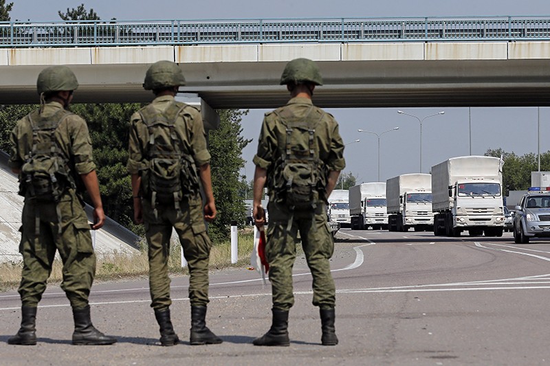 Российские военные наблюдают за передвижением гуманитарного конвоя у Каменск-Шахтинска в 20 километрах от границы с Украиной.