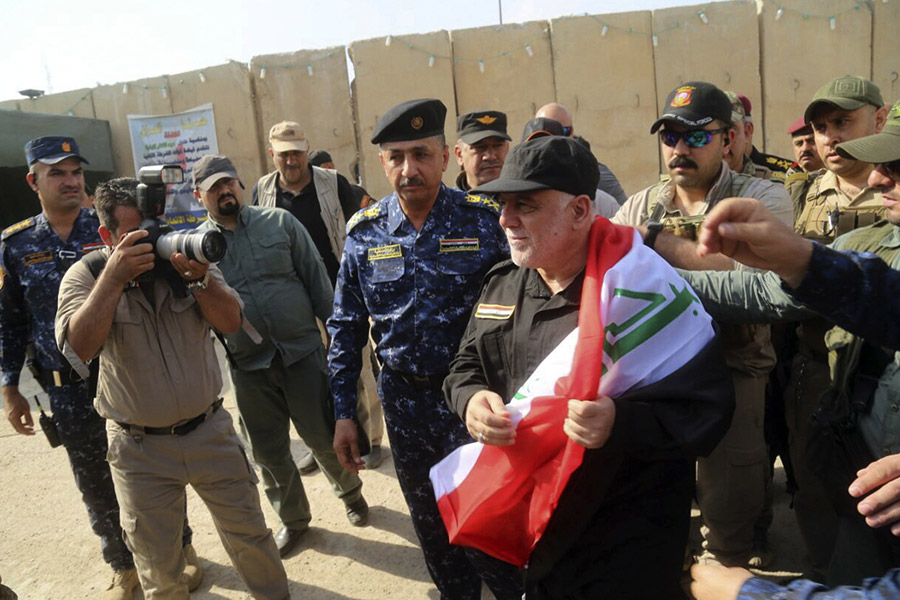 Премьер-министр Ирака Хайдер аль-Абади (в центре) прибыл в Мосул после освобождения города. 9 июля 2017 года
