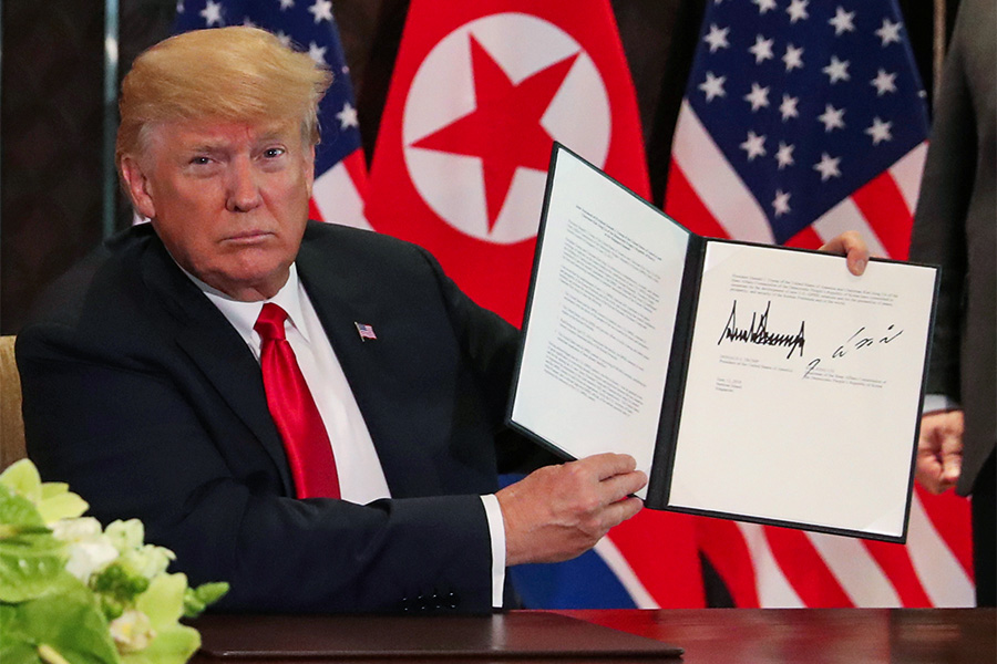 Дональд Трамп демонстрирует документ, подписанный им и лидером Северной Кореи Ким Чен Ыном по итогам саммита. В декларации говорится о приверженности двух стран к становлению &laquo;новых отношений&raquo;, денуклеаризации Корейского полуострова и установлению мира в регионе