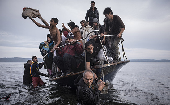 Мигранты прибывают в турецкой лодке на греческий остров Лесбос.&nbsp;Снимок из фотопроекта о беженцах, победившего в номинации &laquo;Новостная фотография&raquo; Пулицеровской премии




