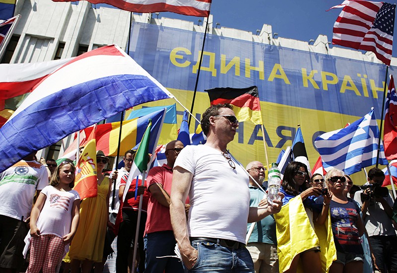 Дипломаты, работники посольств и иностранные сотрудники вышли на улицы Киева с флагами своих стран. Они требовали провести расследование катастрофы самолета «Боинг 777» «Малазийских авиалиний».