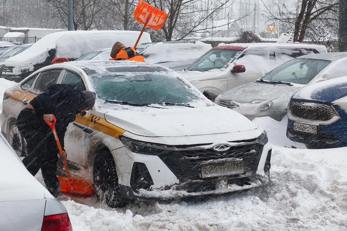 Водитель откапывает свой автомобиль из снега, 9 января 2026 года