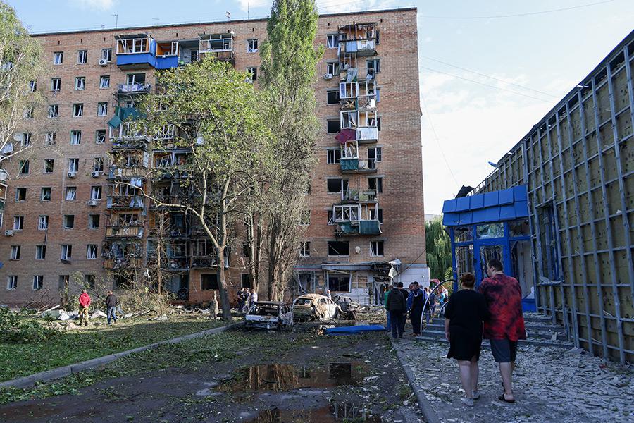 Жители у дома, поврежденного в результате обстрела со стороны ВСУ