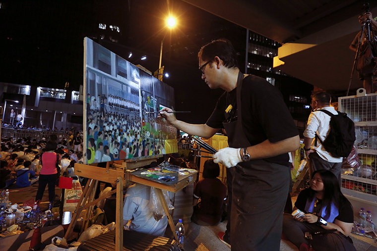 Художник рисует собравшихся на митинг у здания правительства.