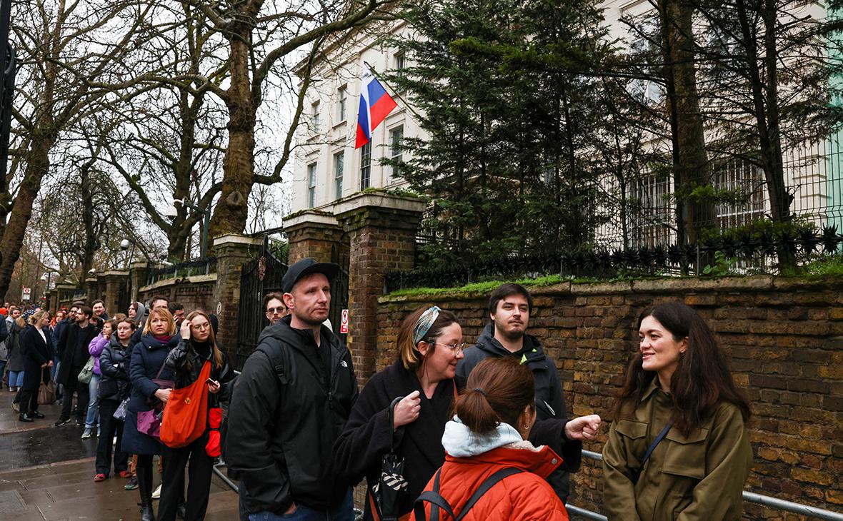 Люди стоят в очереди на голосование у посольства России в Лондоне