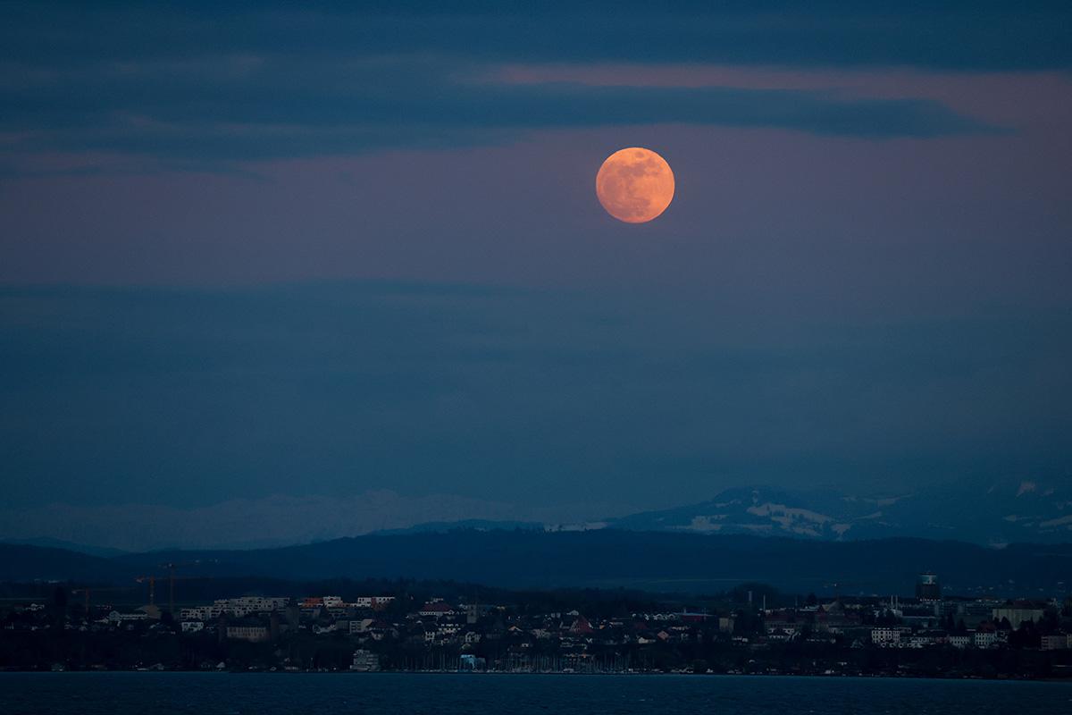 Полная «Розовая Луна» восходит над деревней Эставайер и озером Невшатель, Швейцария, 01 апреля 2026 года