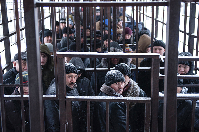 Мигранты из стран ближнего зарубежья стоят в очереди в одном из отделений Управления Федеральной миграционной службы (УФМС) по городу Москве