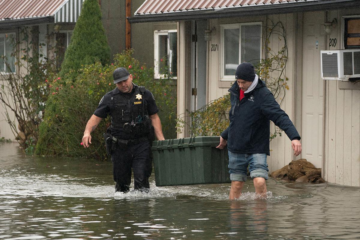 Заместитель шерифа во время эвакуации, город Султан, штат Вашингтон, США, 10 декабря 2025 года.  