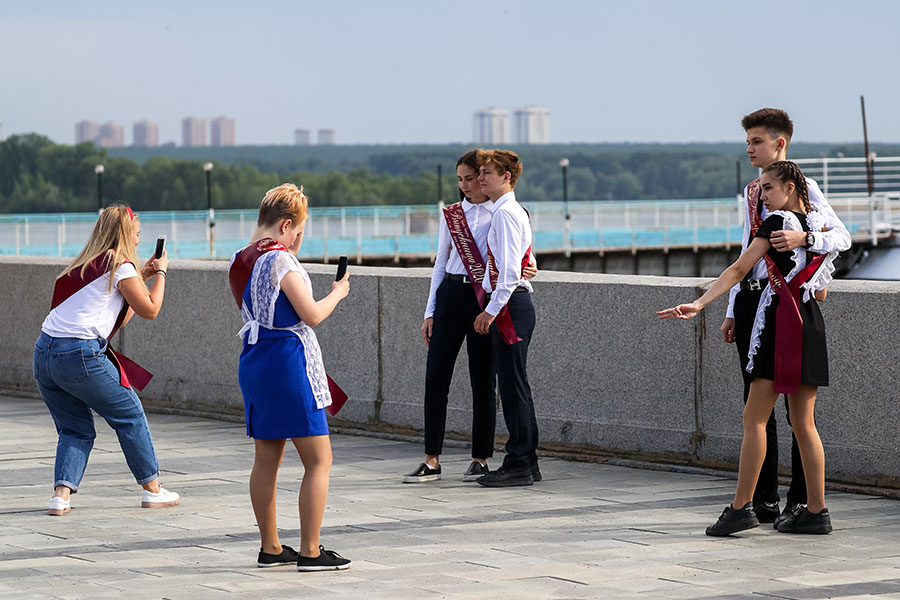 Выпускники одной из школ Новосибирска фотографируются на Михайловской набережной во время праздничных гуляний в честь окончания учебного года
