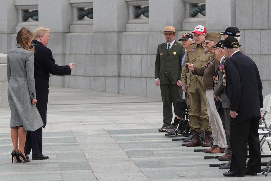 Президент США Дональд Трамп с женой Меланией приветствуют ветеранов Второй мировой войны у мемориала в Вашингтоне
