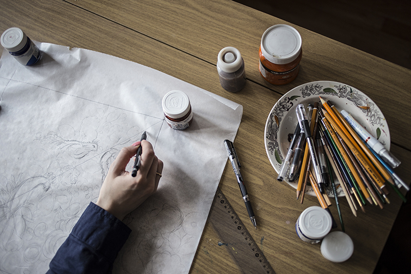Павловопосадский художник создает рисунок для платка — кроки — в натуральный размер гуашью на листе ватмана.