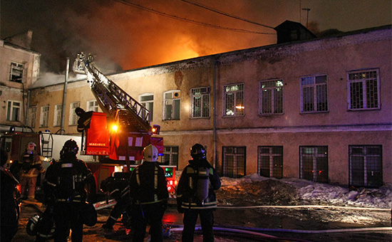Сотрудники пожарной охраны у производственного здания швейного цеха на улице Стромынка, где произошел пожар