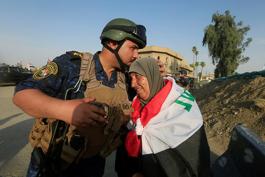 Иракский солдат целует женщину в западной части Мосула. 9 июля 2017 года
