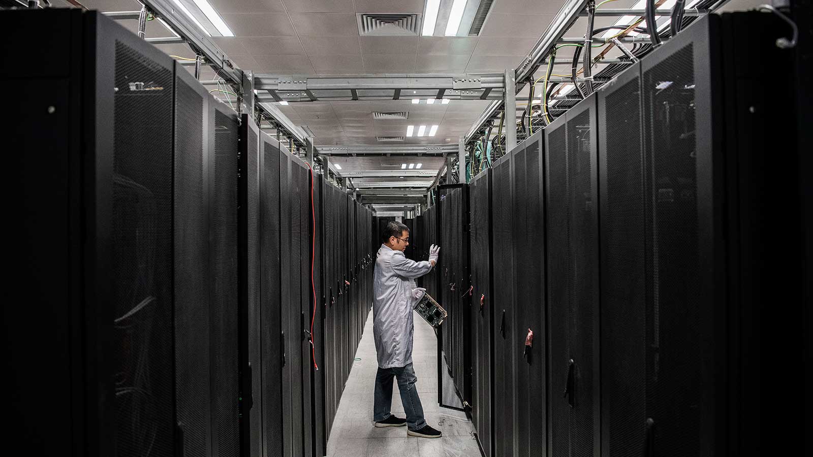 <p>Инженер Huawei открывает дверь серверного блока в лаборатории кибербезопасности производственного кампуса компании</p>