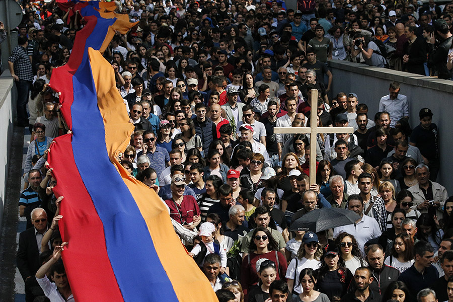 Участники памятных мероприятий несут к мемориалу памяти жертв геноцида огромный флаг Армении