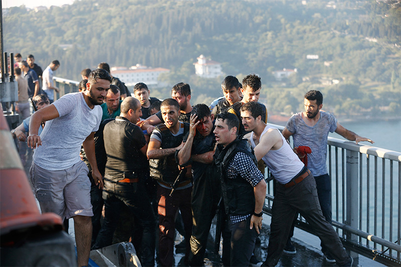 Полицейские защищают причастного к мятежу военного &nbsp;на мосту через&nbsp;Босфор



