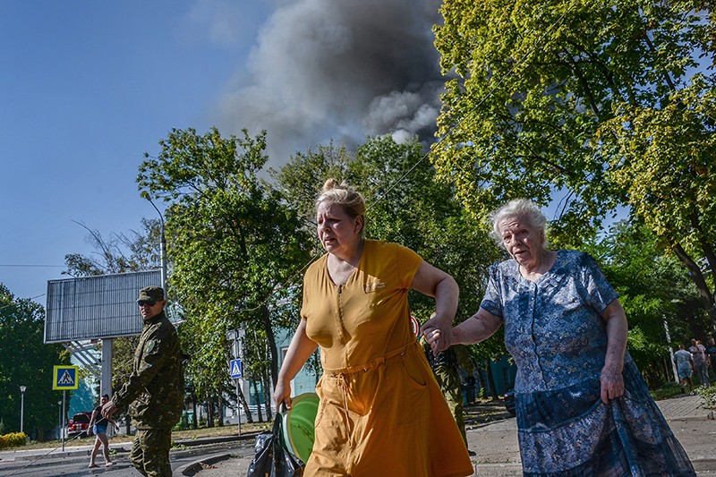 Пожилые женщины переходят улицу после из обстрела Донецка. В четверг, 28 августа, советник министра внутренних дел Украины Зорян Шкиряк заявил, что Россия начала полномасштабное вторжение на территорию страны. 