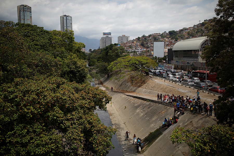 В Каракасе народ также приходит наполнять канистры к реке Гуайре, в которую попадает большое количество сточных вод
