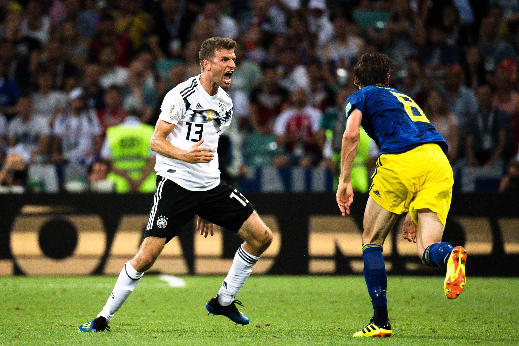 Атакующий полузащитник сборной Германии Томас Мюллер (слева) против шведского хавбека Альбина Экдаля