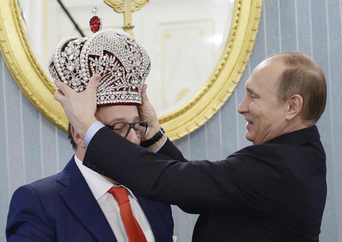 Владимир Путин надевает копию императорской короны на художественного руководителя московского Театра эстрады Геннадия Хазанова&nbsp;во время встречи в Кремле, 2015 год