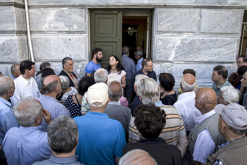 Граждане, преимущественно пенсионеры, ругаются с&nbsp;сотрудниками отделения Национального банка Греции, которое было закрыто
