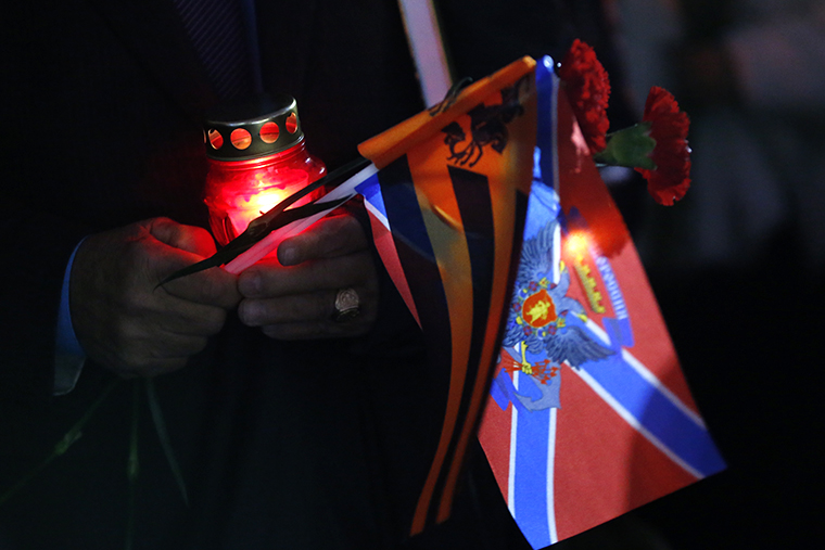 Свеча в руках у участника акции скорби по убитым мирным жителям в Донецкой области на Поклонной горе.