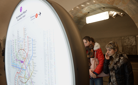Пассажиры у информационного стенда на станции метро "Кузнецкий мост"
