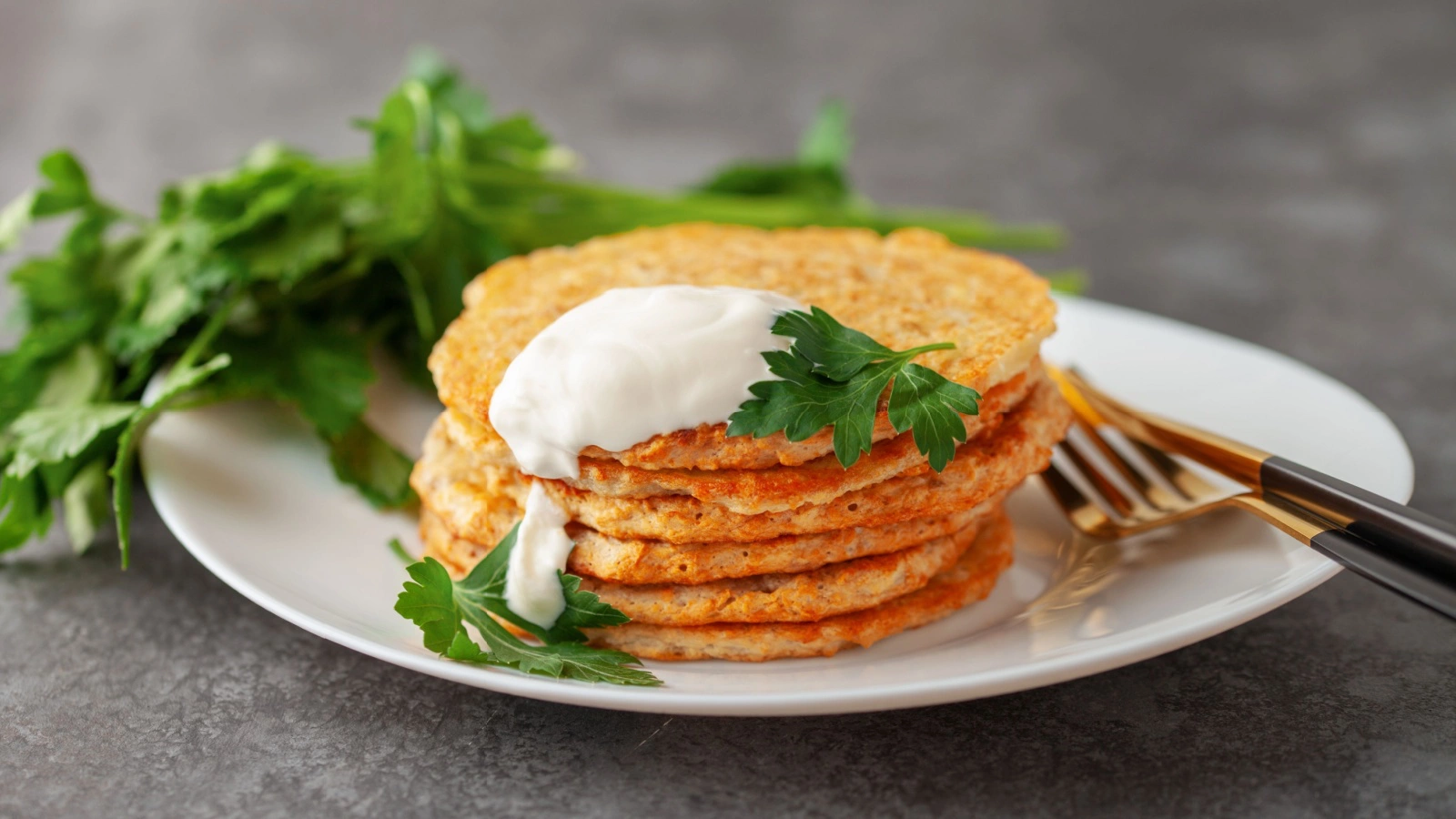 Картофельные драники лучше подавать горячими, сразу после жарки, со сметаной, чесночным соусом или зеленью