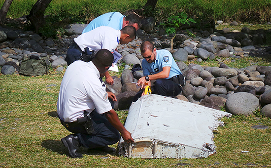 Французские жандармы осматривают найденный на острове Реюньон фрагмент самолета