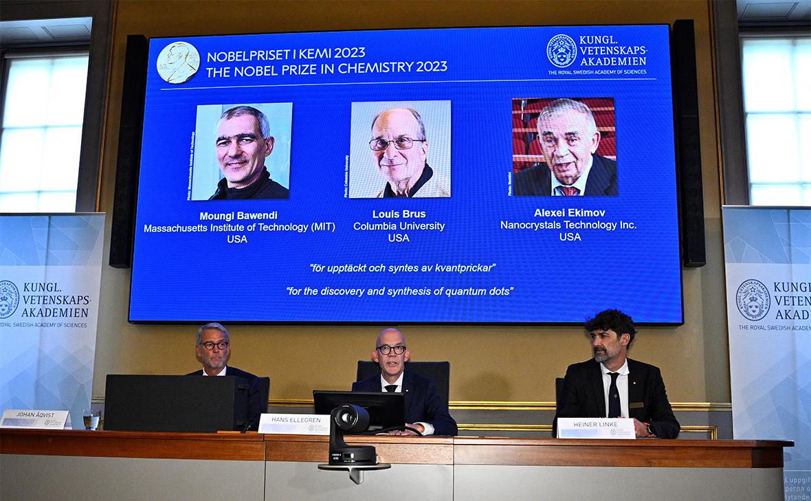 Лауреаты Нобелевской премии по химии 2023 года (на экране) Мунги Бавенди, Луис Брюс и Алексей Екимов