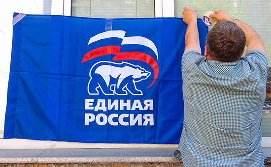 Член избирательной комиссии вешает флаг во время предварительного голосования на одном из избирательных участках города, май 2016 года


