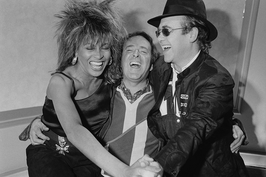 Тина Тернер, ведущий ток-шоу Терри Воган и певец и пианист Элтон Джон (справа) в телецентре Би-би-си, Лондон, 18 февраля 1985 года