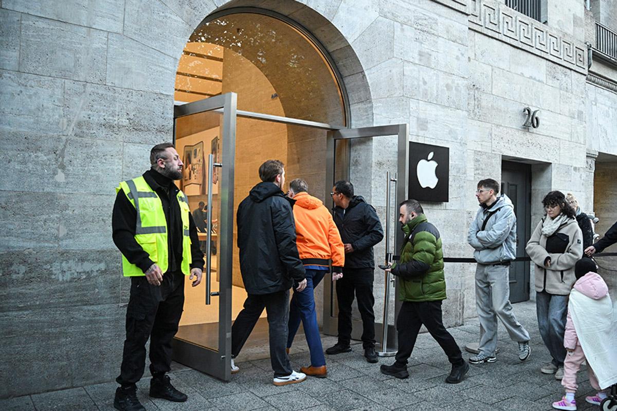 Люди заходят в магазин Apple в день начала продаж нового складного iPhone Duo; Берлин, Германия, 23 октября 2026 года