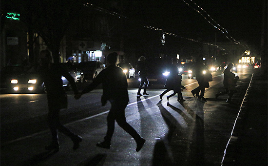 Жители Симферополя переходят автодорогу в свете фар автомобилей. Крым, 22 ноября 2015 года