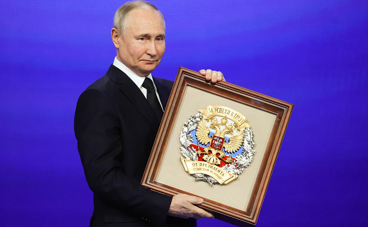 Владимир Путин держит почетный знак Российской Федерации &laquo;За успехи в труде&raquo;